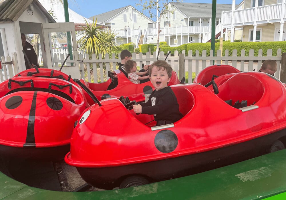 Small child on a ladybug ride at the fairgound at Butlins